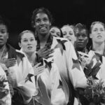 During a ceremony, a group of female athletes in star-patterned jackets stands with hands on hearts and holding bouquets. Their poised presence lends an atmosphere as formal as one might find in Type II Meeting Rooms.