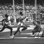 During a Type I Meeting Room event, two athletes sprint on a track amidst the roar of the crowd in the stadium.